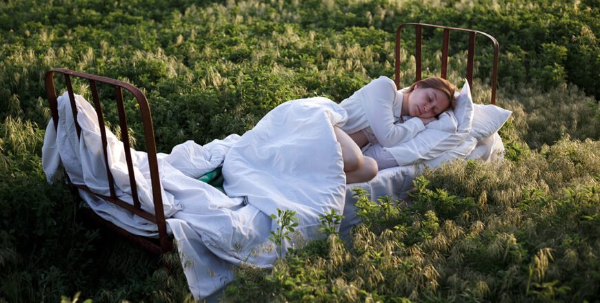 femme qui dort dans un lit dans un champ
